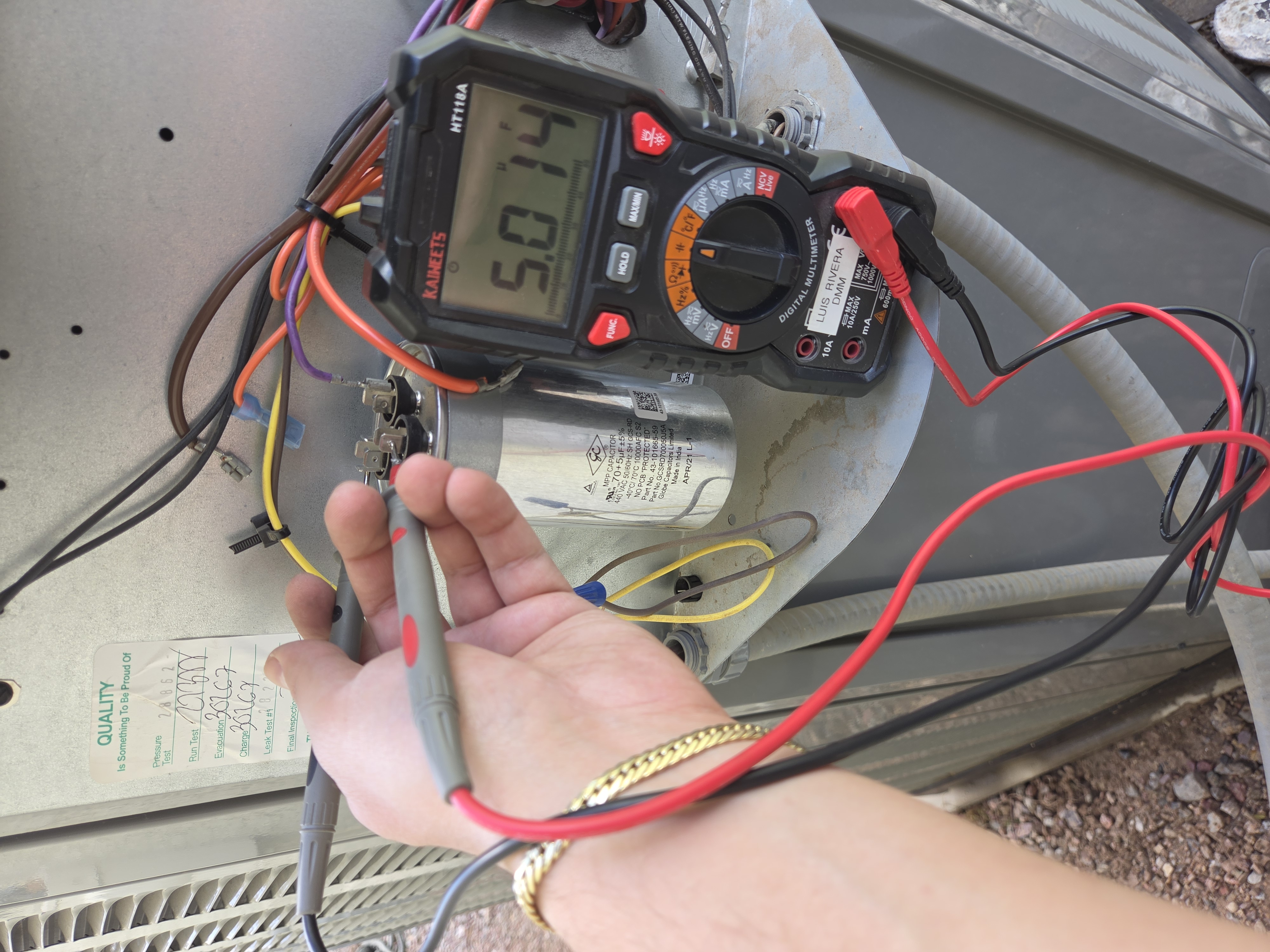 Digital multimeter checking dual run capacitor during service