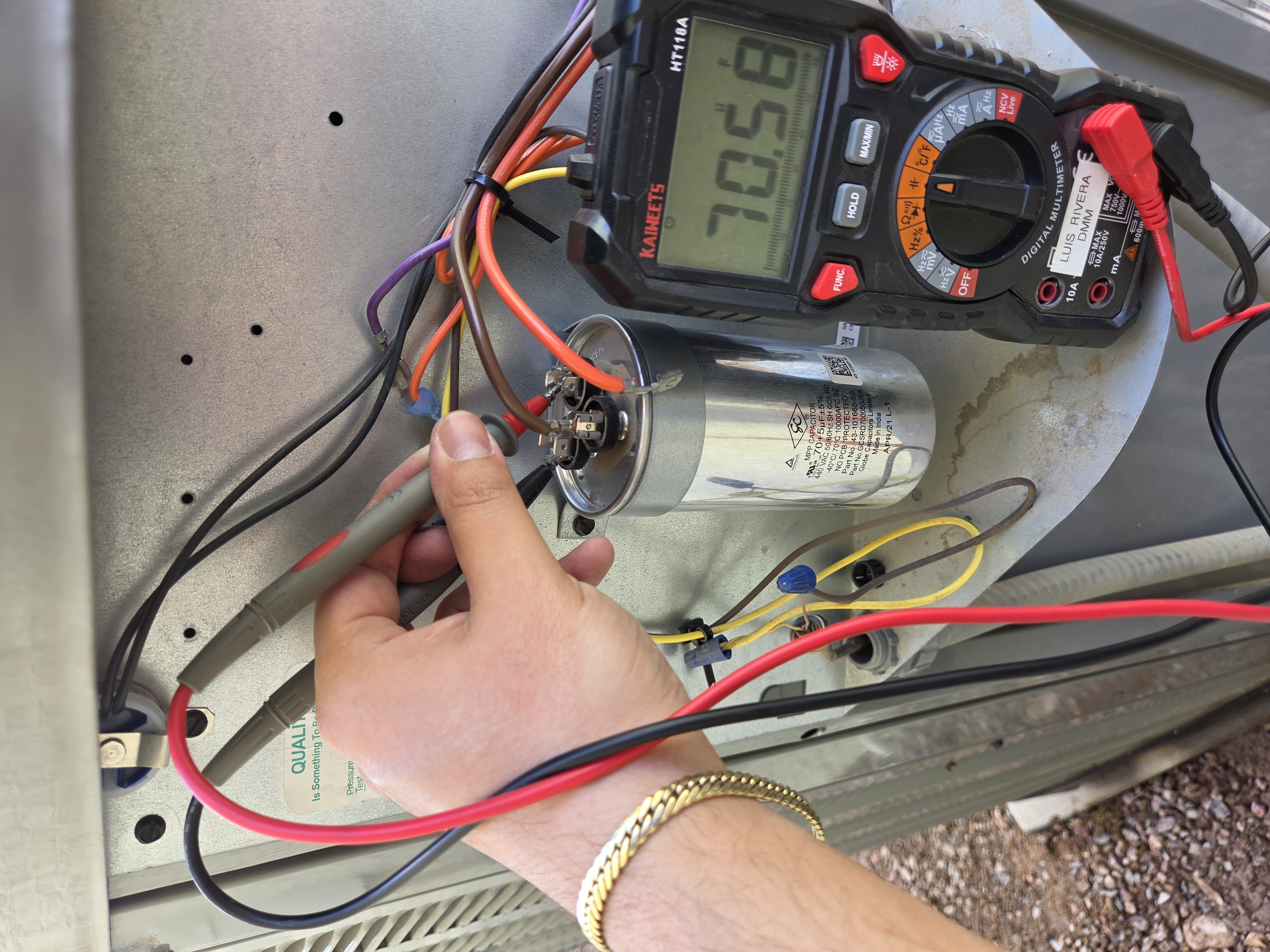 Digital multimeter checking dual run capacitor during service