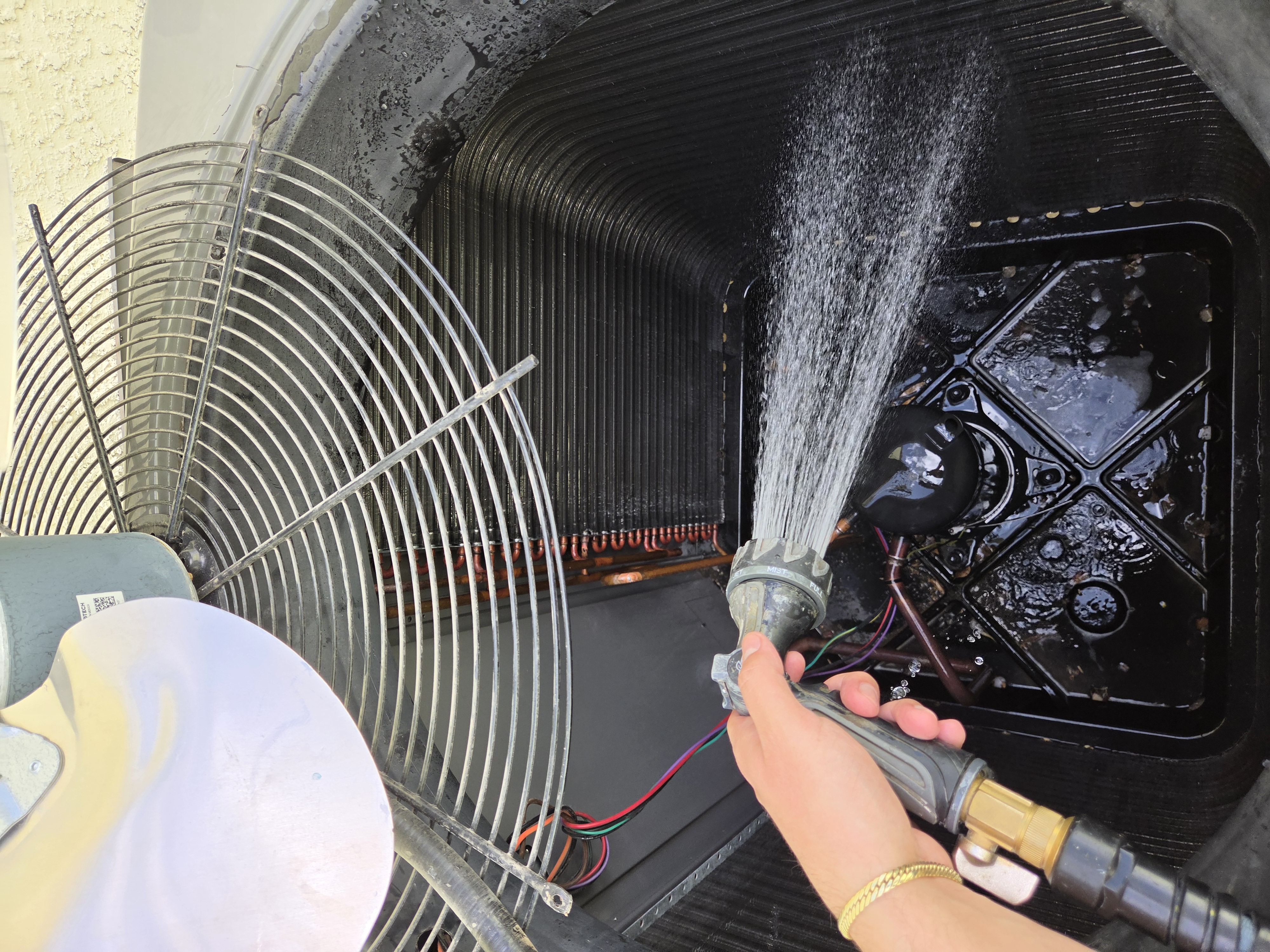 Condenser coil being rinsed with water spray