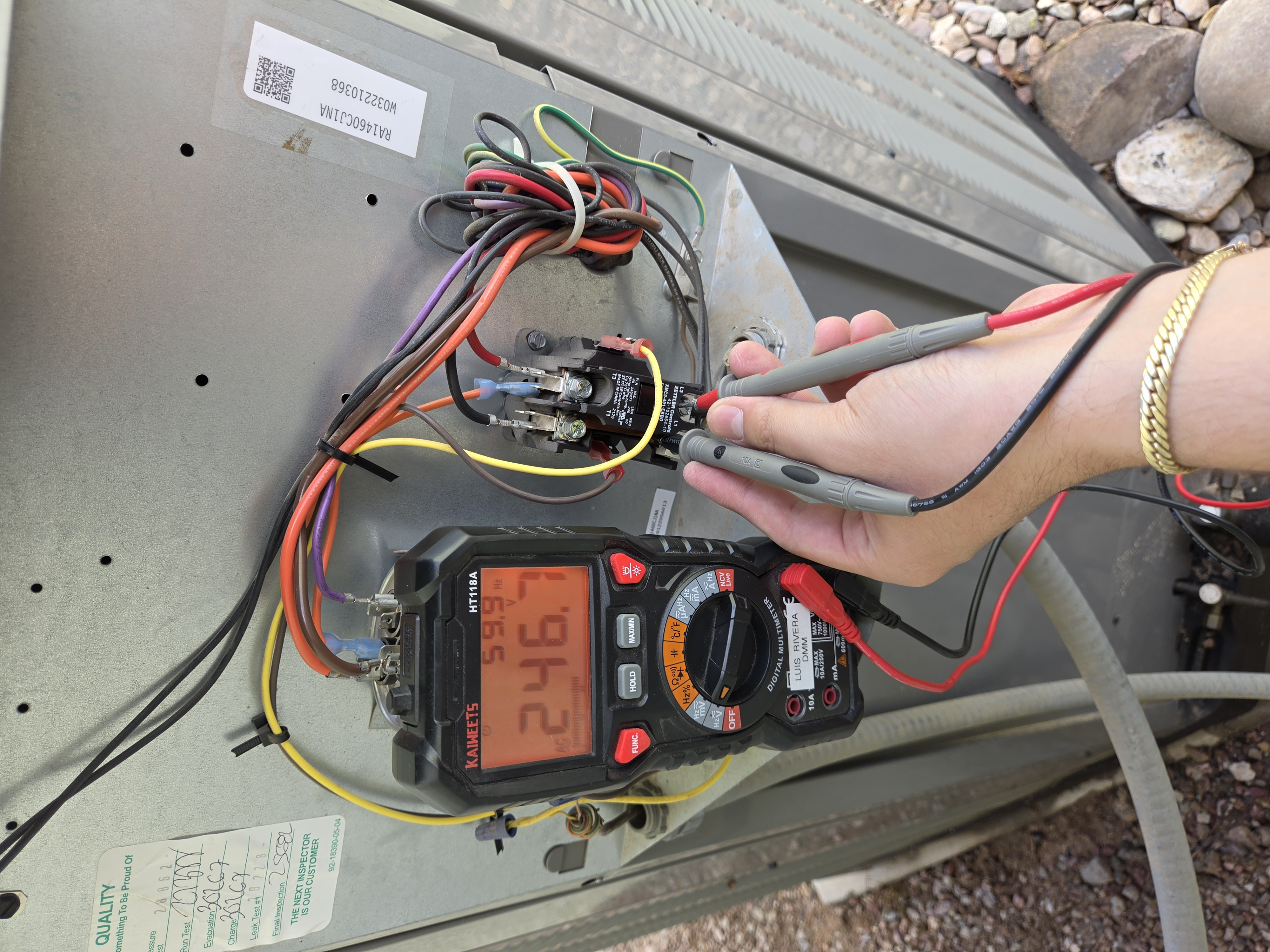 Digital multimeter checking AC line voltage at contactor during service