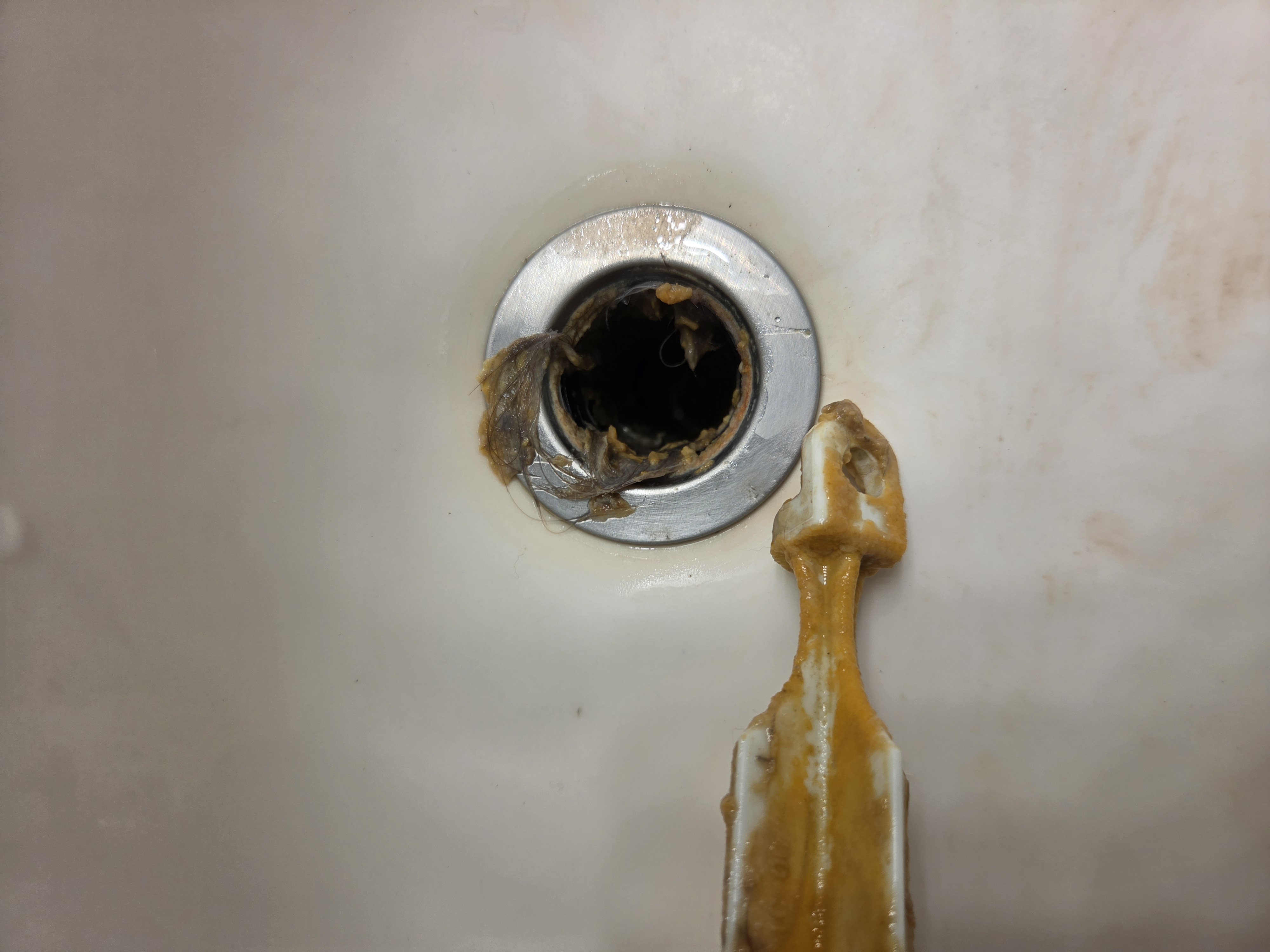 Sink drain buildup removed during clog service